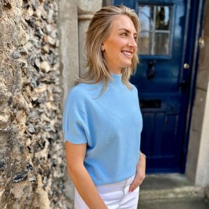 Nicola Sexton baby blue short sleeve knit with high neck and cuffed sleeves styled with white trousers